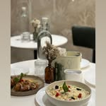 A cozy table set with pasta and coffee at Cafuné by Lee